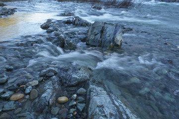 Rapid water flowing river with harsh rocks