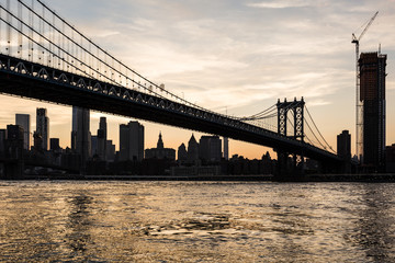 Fototapeta na wymiar Stunning sunset over the Manhattan bridge and the Manhattan financial district across the East river from Brooklyn in New York City, USA