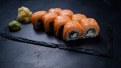 Philadelphia sushi rolls on dark background. Oriental cuisine and Japanese food concept