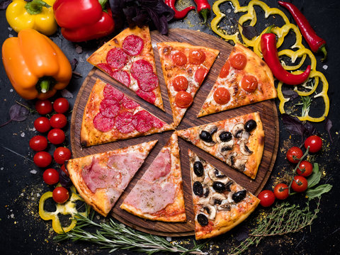traditional italian food cuisine. delicious pizza slice quattro stagioni with ham prosciutto tomatoes olives and mushrooms
