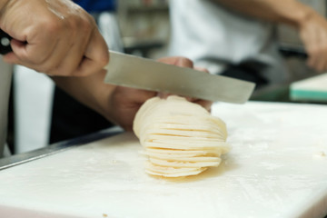 Chef training cut vegetable on cutting board with knife japan