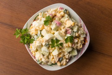 Salad with crab sticks, sweet corn, cucumber, eggs and mayonnaise