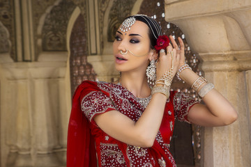 Beautiful young indian woman in traditional clothing with bridal makeup and oriental jewelry.