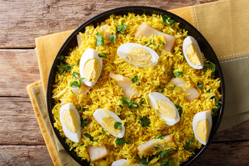 Kedgeree curry rice with smoked fish, eggs, cilantro close-up on a plate. horizontal top view