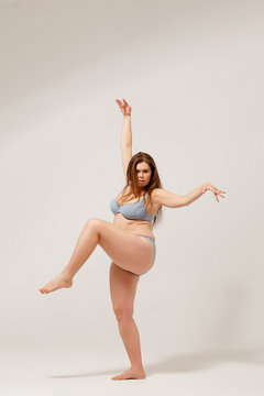 Young overweight female posing on camera in underwear.