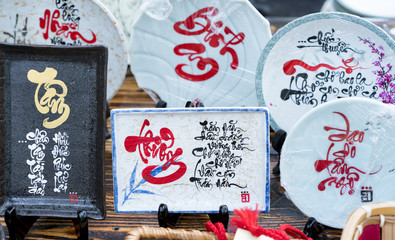 Written speaker sentence Lunar New Year art of ceramics with text "Happy, Merit, Fortune, Longevity, Peace" in Vietnamese used to decorate indoors as traditional Vietnamese traditional Lunar New Year