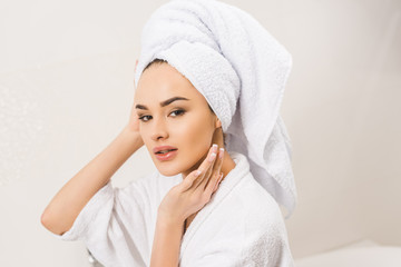 Obraz premium portrait of beautiful young woman in bathrobe with towel on head at home