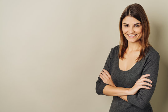Happy vivacious young woman with folded arms