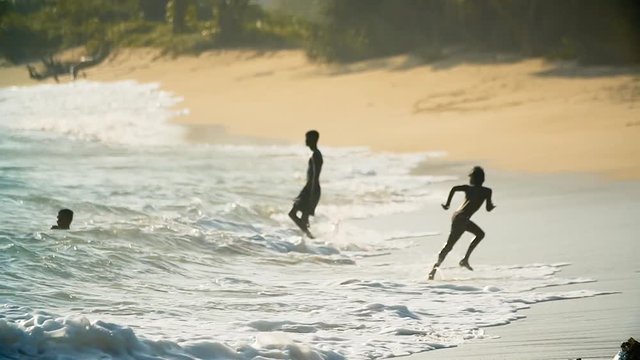 Little positive boy runs away from the wave