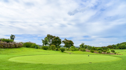 The green grass on golf course with blue cloud sky background