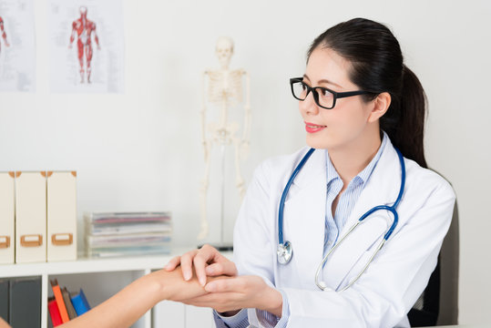 attractive woman doctor touching patient hand
