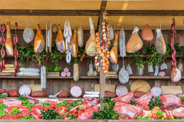 fresh food market background with raw pork and vertical assorted salami sausages.