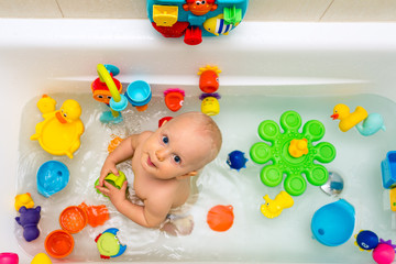 Baby boy taking a bath, playing with colorful toys