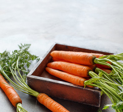 Fresh raw carrots with leaves in a box