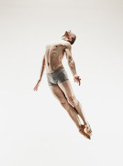 The male athletic ballet dancer performing dance isolated on white background.