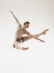 The male athletic ballet dancer performing dance isolated on white background.