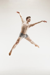 The male athletic ballet dancer performing dance isolated on white background.