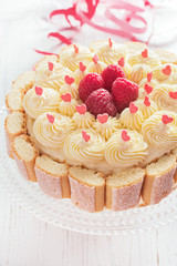 Cake with butter cream and fresh raspberries for Valentine's Day or mother's day on white wooden background,