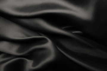 Elegant black satin silk with waves, abstract background