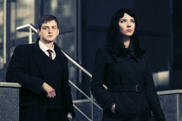 Young fashion business couple against office building