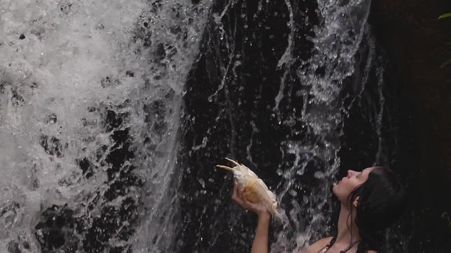 Tropical forest jungle with waterfall in slow motion, 180 frames per second, speed slowed down to 29.97fps , water falling down in shadow of trees