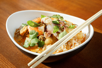 Asian riсe with seafood - shrimps and octopus -with sause in oval plate with bamboo sticks
