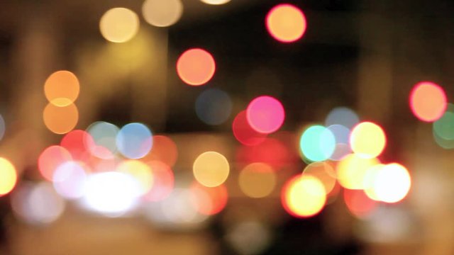 Urban scene of unfocused traffic lights and cars lights in the city at night