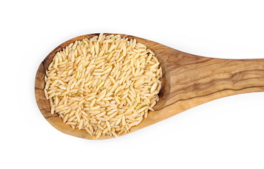 Integral, long grain brown rice pile in wooden spoon isolated on white background