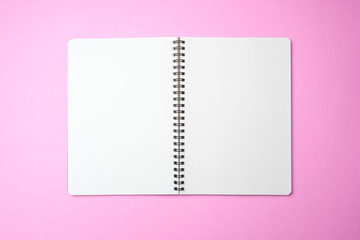 white blank notebook opened on pink color background