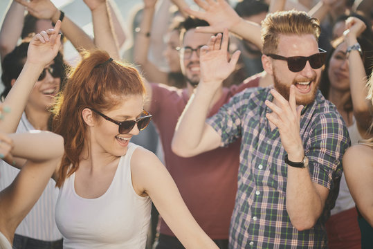 Group of people dancing and having a good time at the outdoor party/music festival 