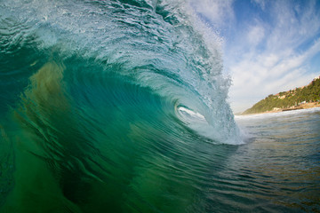 inside view of a barreling wave breaking on a beach