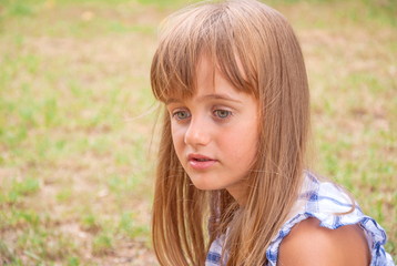 Portrait of sad, brooding little girl with big gray eyes