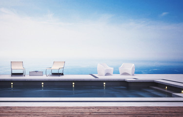 Swimming pool with deckchairs against sea
