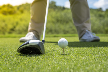 Golfer put golf ball on tee preparing shot on to golf hole