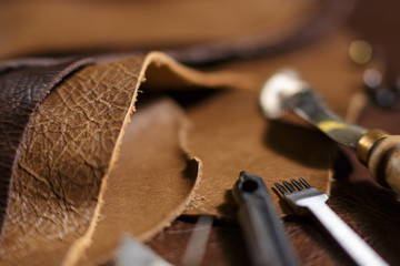 Crafting tools on natural cow leather in the tailoring workshop. Close up