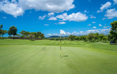 Obraz premium The White flag on hole of golf with blue could background
