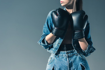 partial view of stylish girl posing with boxing gloves, isolated on grey