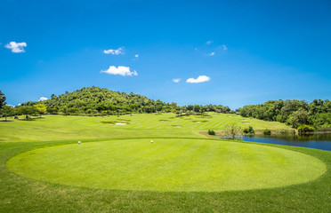 Green grass and trees at golf course with blue cloud sky background 