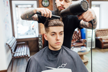 man getting trendy haircut at barber shop.