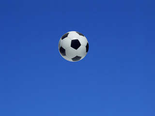 Fototapeta na wymiar A soccer ball shot in the air with blue sky background