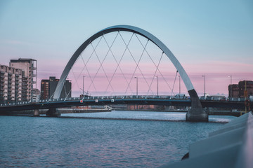 Obraz premium View of the Clyde Arc or Squinty Bridge from the East at sunset and river Clyde, Glasgow, Scotland