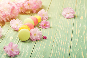 Flower and macarons pattern on a greenery background.