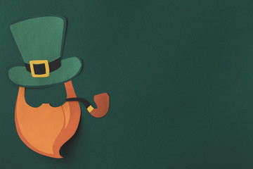 top view of paper decoration of man with smoking pipe for st patricks day isolated on green