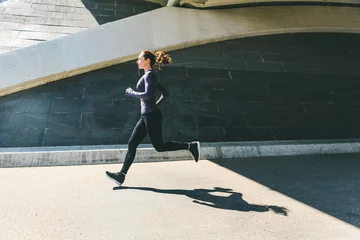 Fototapeten Frau joggt oder läuft, Seitenansicht mit Schatten © william87
