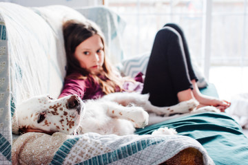 A Girl and Her Dog Relaxing on a Couch