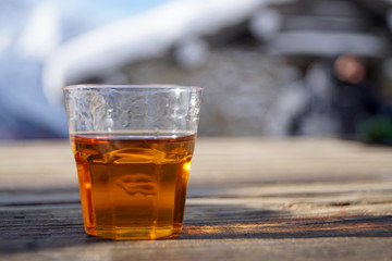 Bicchiere di liquore appoggiato sul tavolo di legno di una baita in montagna 