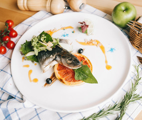 summer bright dish, restaurant serving of fish seabass with grapefruit on a grill