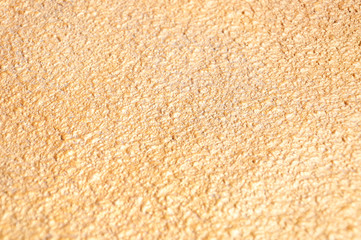 Golden textured uneven wall. Close-up with blurred background.  Abstract background and texture for...
