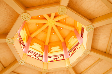 Abstract photo wooden yellow round ceiling with Asian symbols, columns and balcony