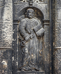 Black medieval religious bas-reliefs on the walls of an ancient church